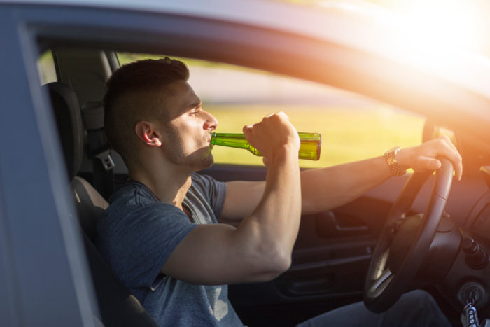 Man drinking a beer while driving