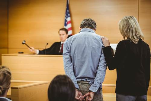 Man in handcuffs standing before a judge in court