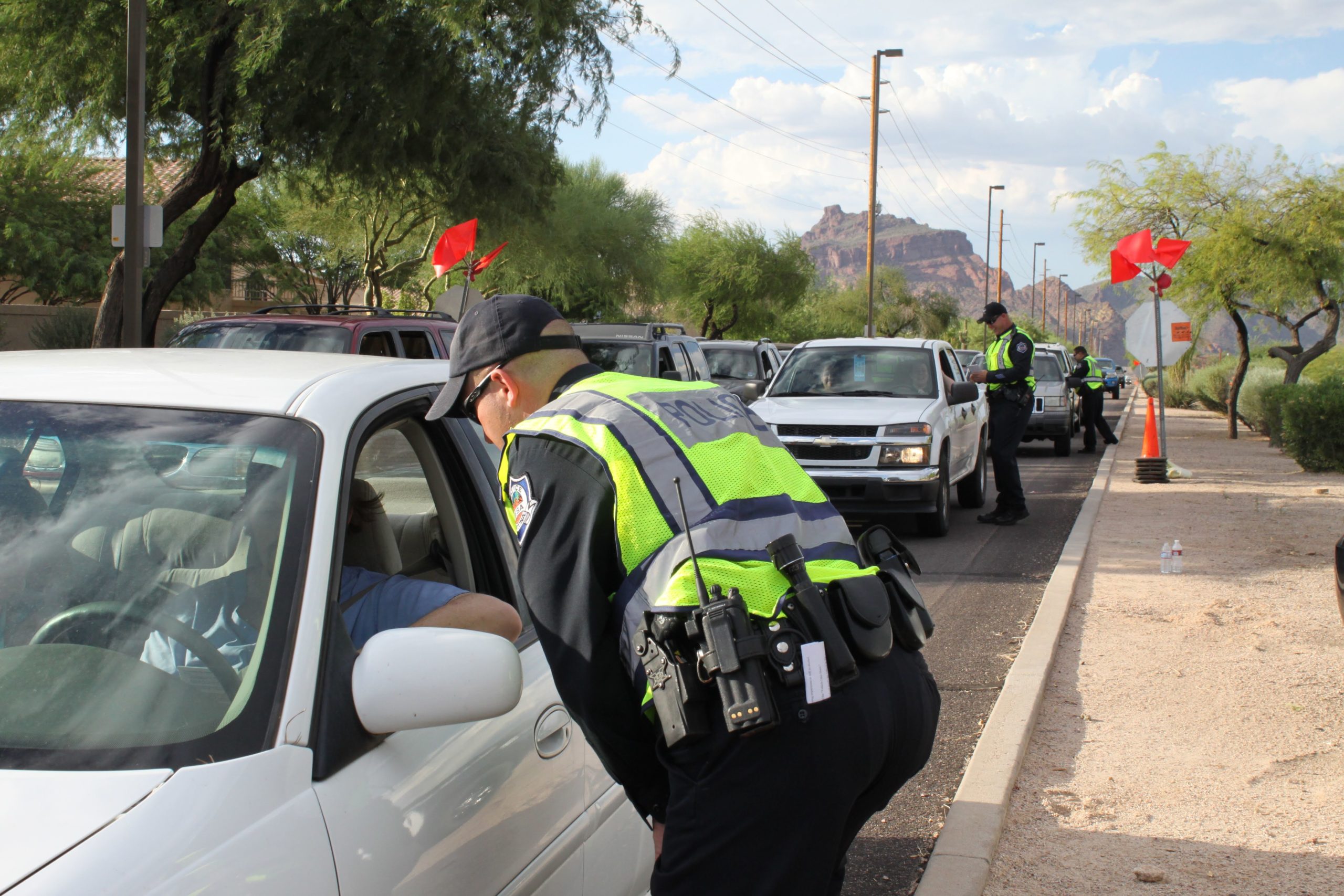 Officer stopping a white car at a DUI/Sobriety checkpoint in Nevada