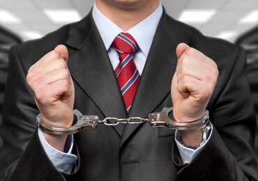 man handcuffed after being arrested for a white collar crime in Las Vegas