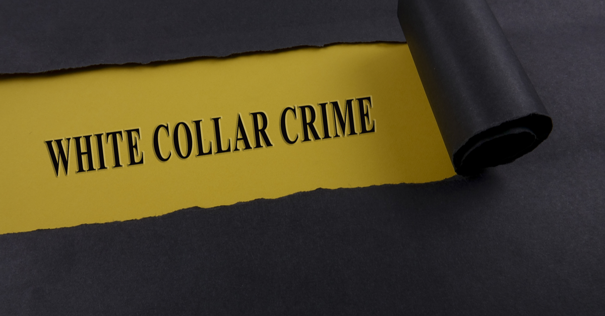Torn black paper on yellow surface with "white-collar crime" written
