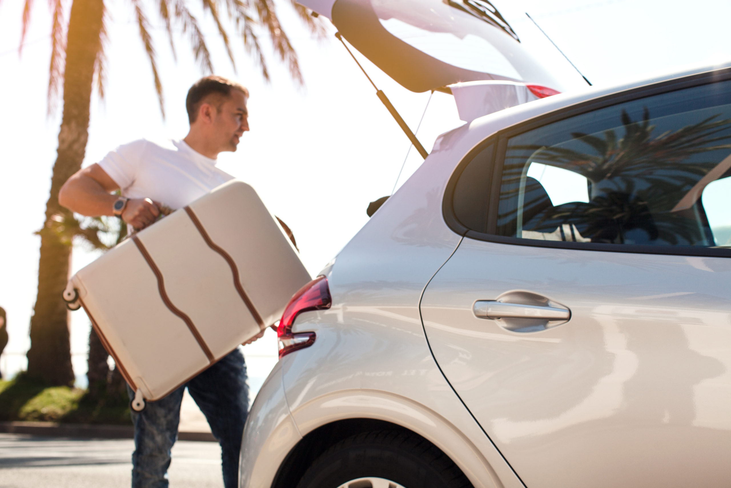 man putting luggage in the back of a rental vehicle in Las Vegas, NV