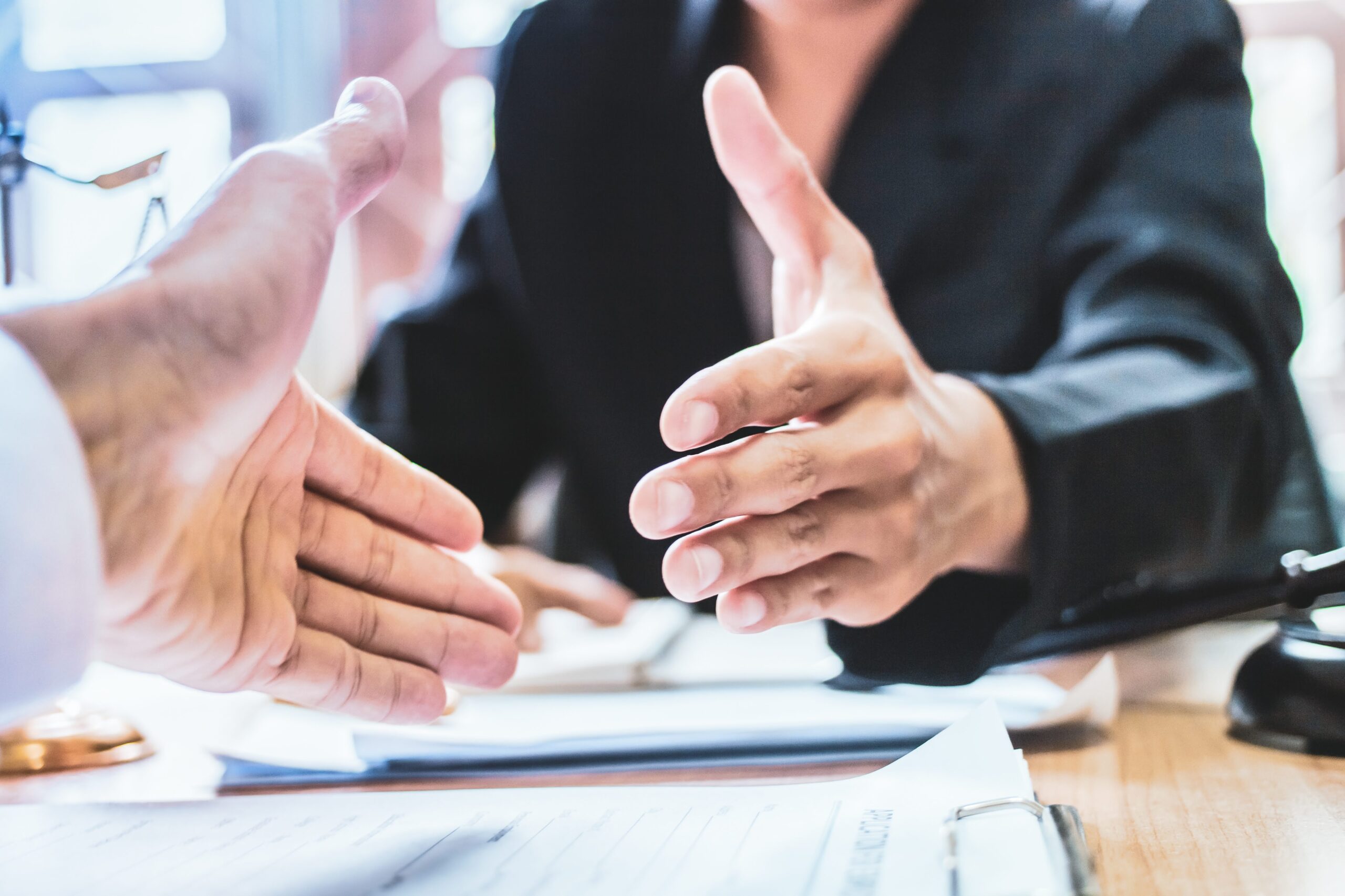 Criminal Defense Attorneys shaking hands at a desk