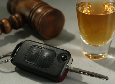 gavel, car key, and alcohol on table - DUI concept