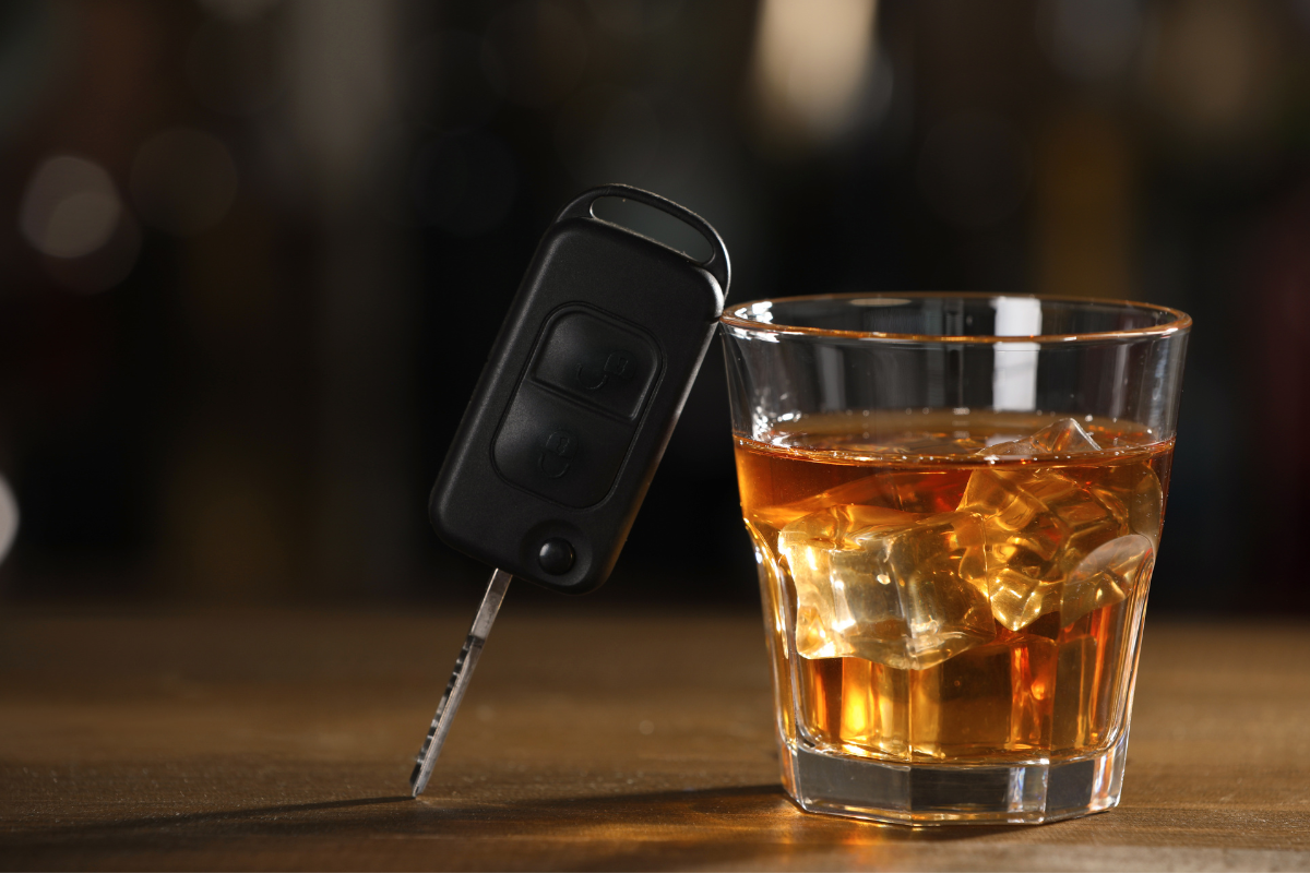 a car key and a bottle of whiskey - representing DUI